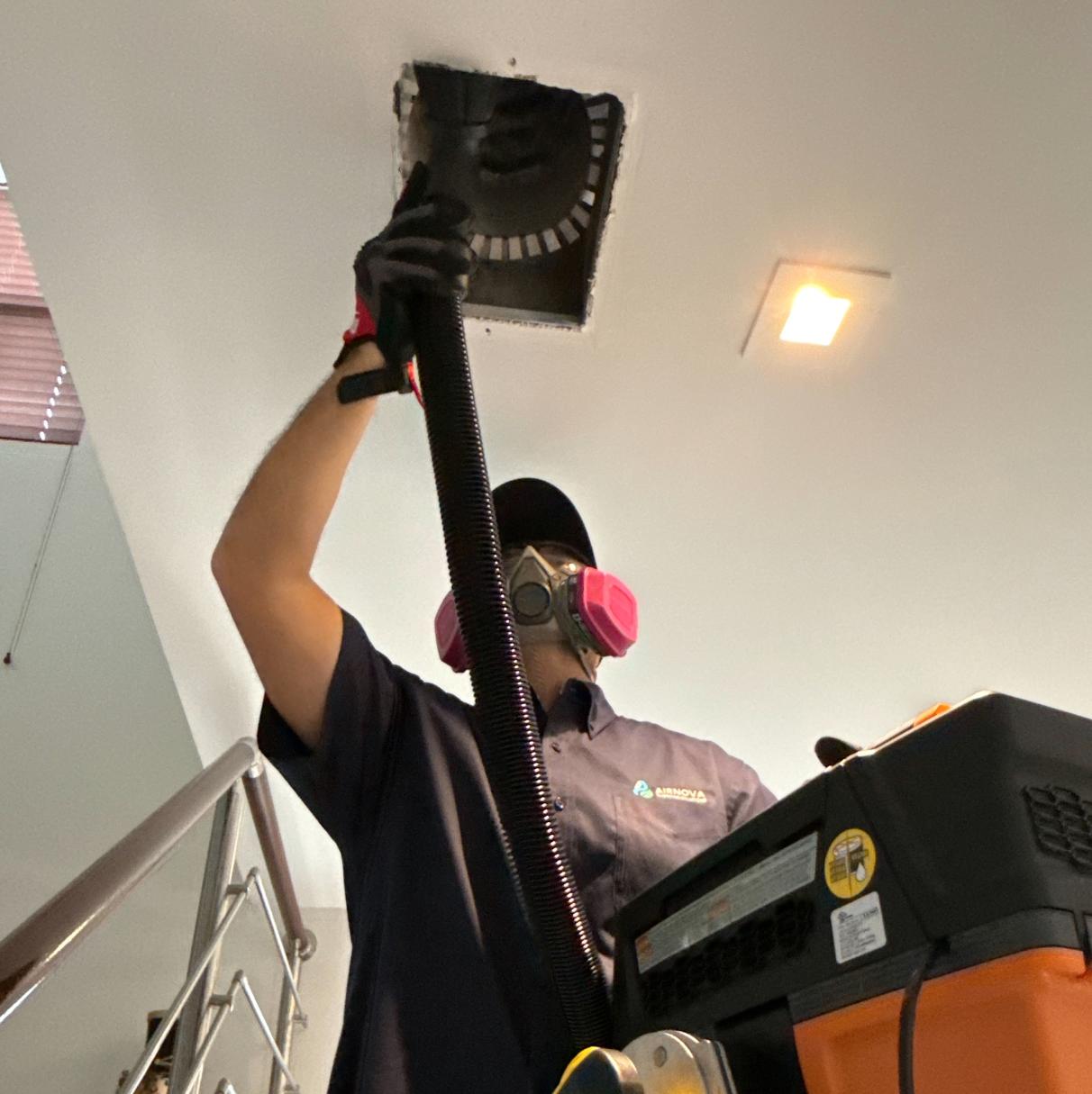 Professional HVAC air duct cleaning by AirNova Cleaning Solutions technician using vacuum equipment in Miami, Florida